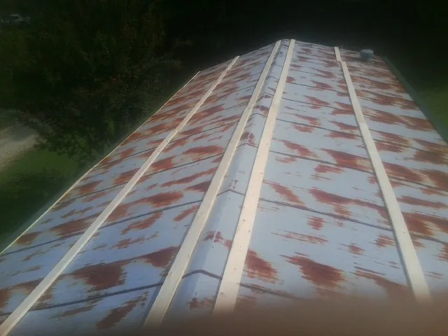 Rusted metal roof panels with new wood purlins before replacement — Storm Damage Roof Repair in Tyler by Roofing Brothers