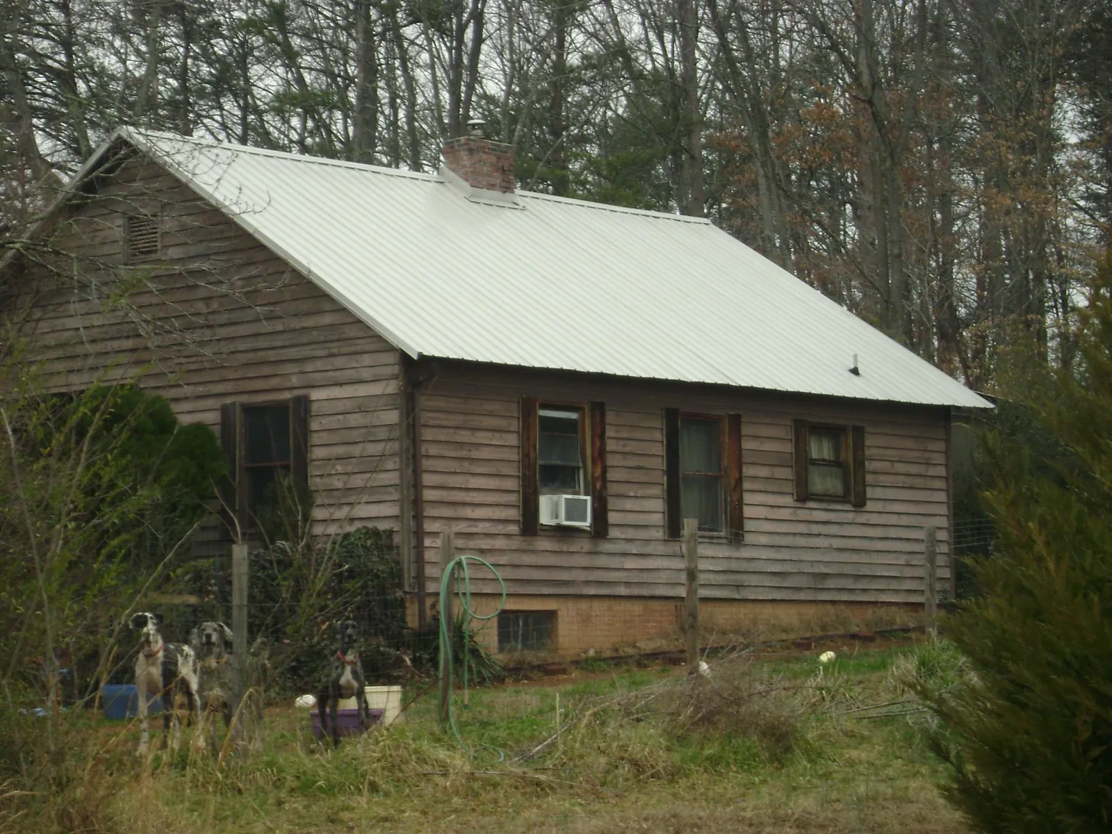White metal roof on an old wood sided farmhouse, from a Metal Roof Installation job in Tyler